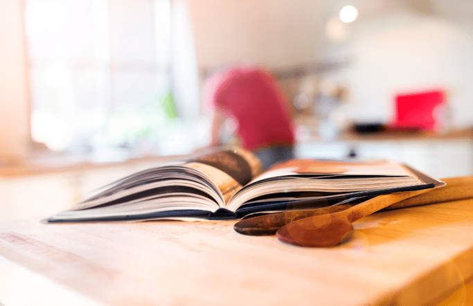 open photo book on wooden spoons and cutting board