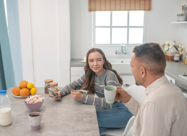 father and daughter talking at the table