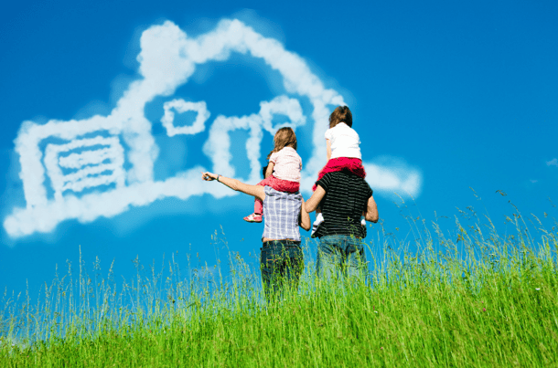 couple with kids on shoulders looking at house-shaped cloud