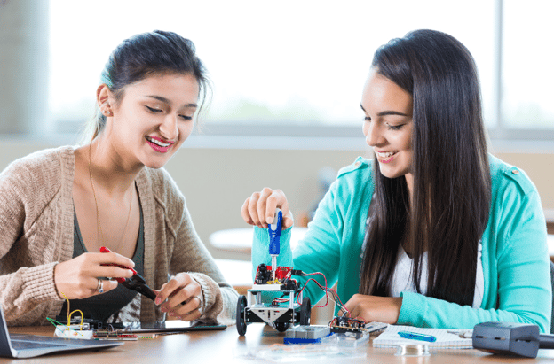 two teen girls doing robotics