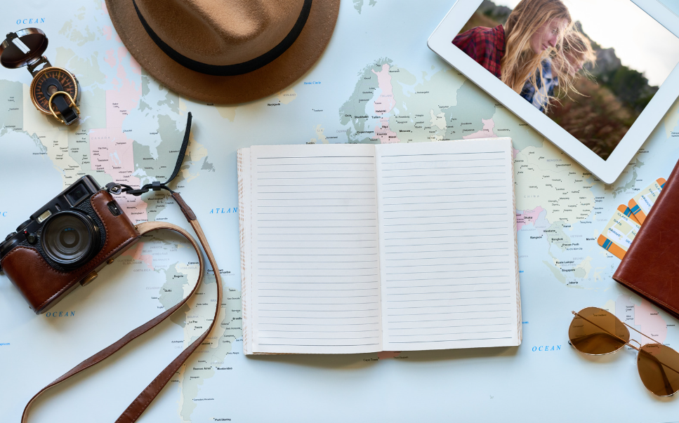 journal and travel supplies on world map