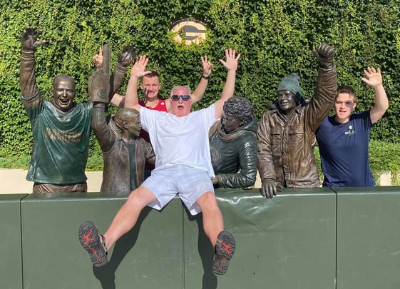 Boys and host dad posing with Packers statues