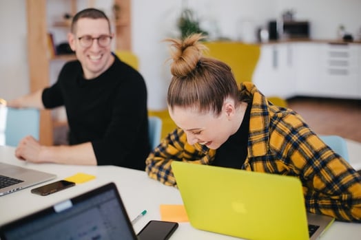 young people talking and laughing at their computers