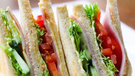 layered sandwich with veggies cheese and ham