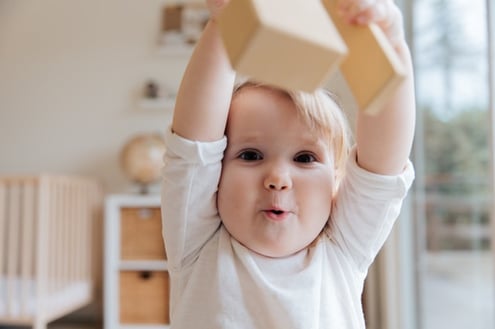 baby raising hands above head