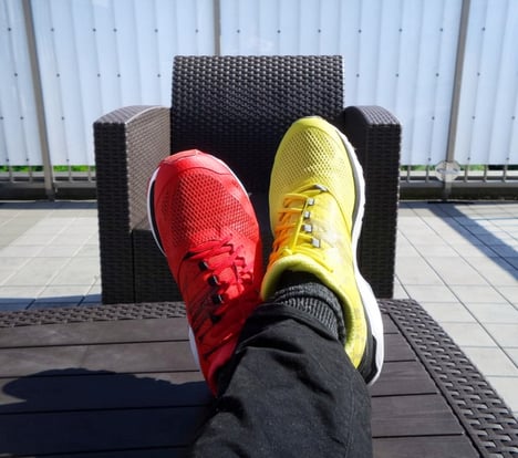 male feet wearing two different colored shoes