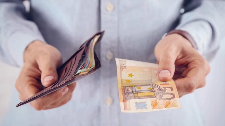 man holding wallet and fifty euros