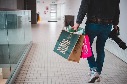 man with two shopping bags at mall