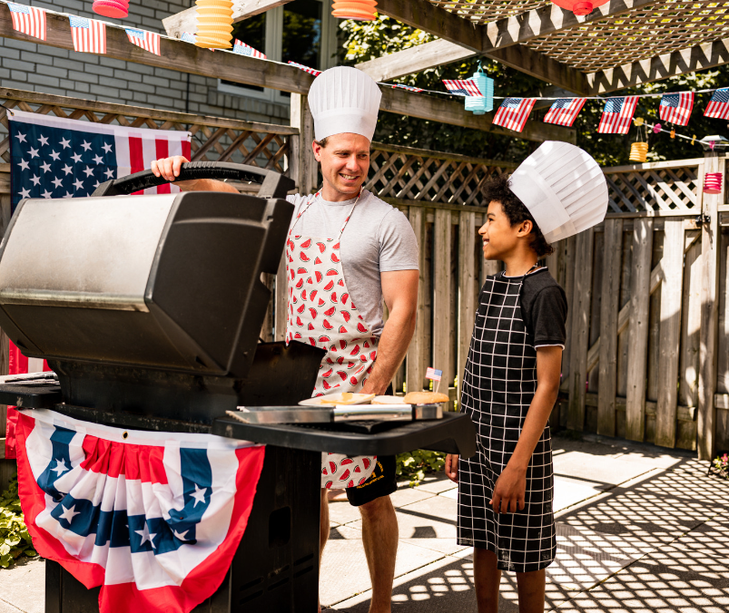 man and boy grilling with red, white, & blue decor