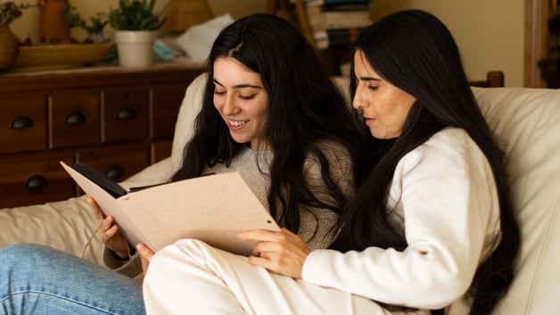 mother and daughter looking through photo album