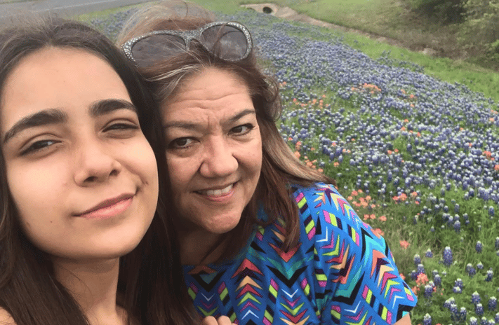 mother and daughter smiling together in a field of flowers