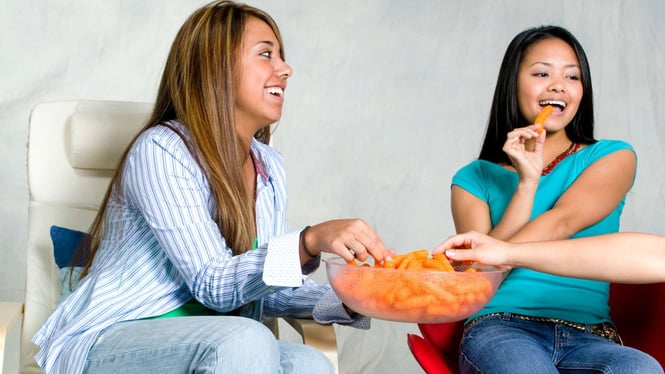 mother and teenage girl eating snacks together