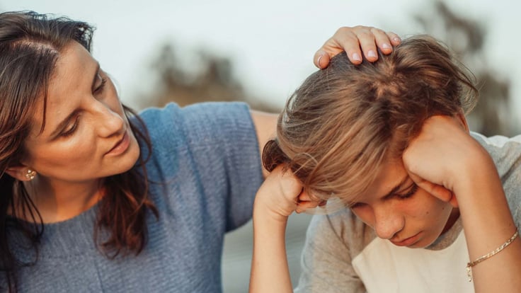 mother talking to sad teenage boy