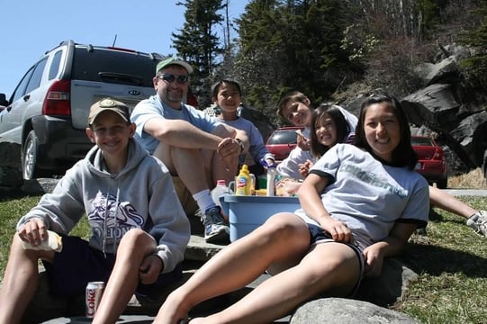 mother, father and four children having a picnic in nature