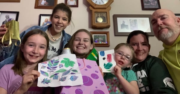 parents with three daughters displaying homemade gifts