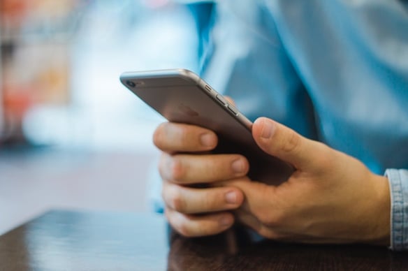 a boy's hands holding a cell phone