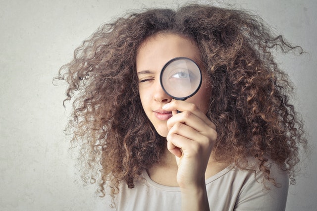 girl with magnifying glass up to her eye