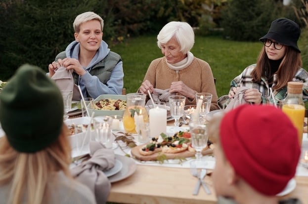 A family eating outside together at a picnic table