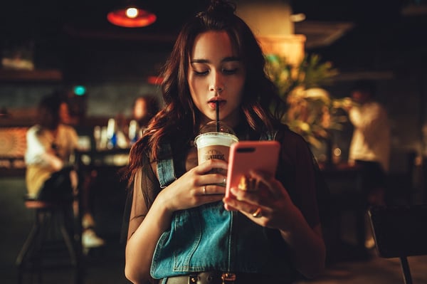 girl on phone and drinking coffee