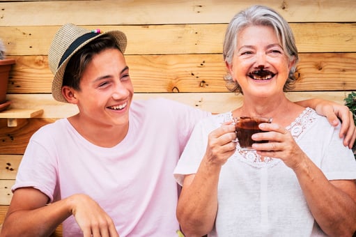 teen boy laughing with senior woman with chocolate mustache