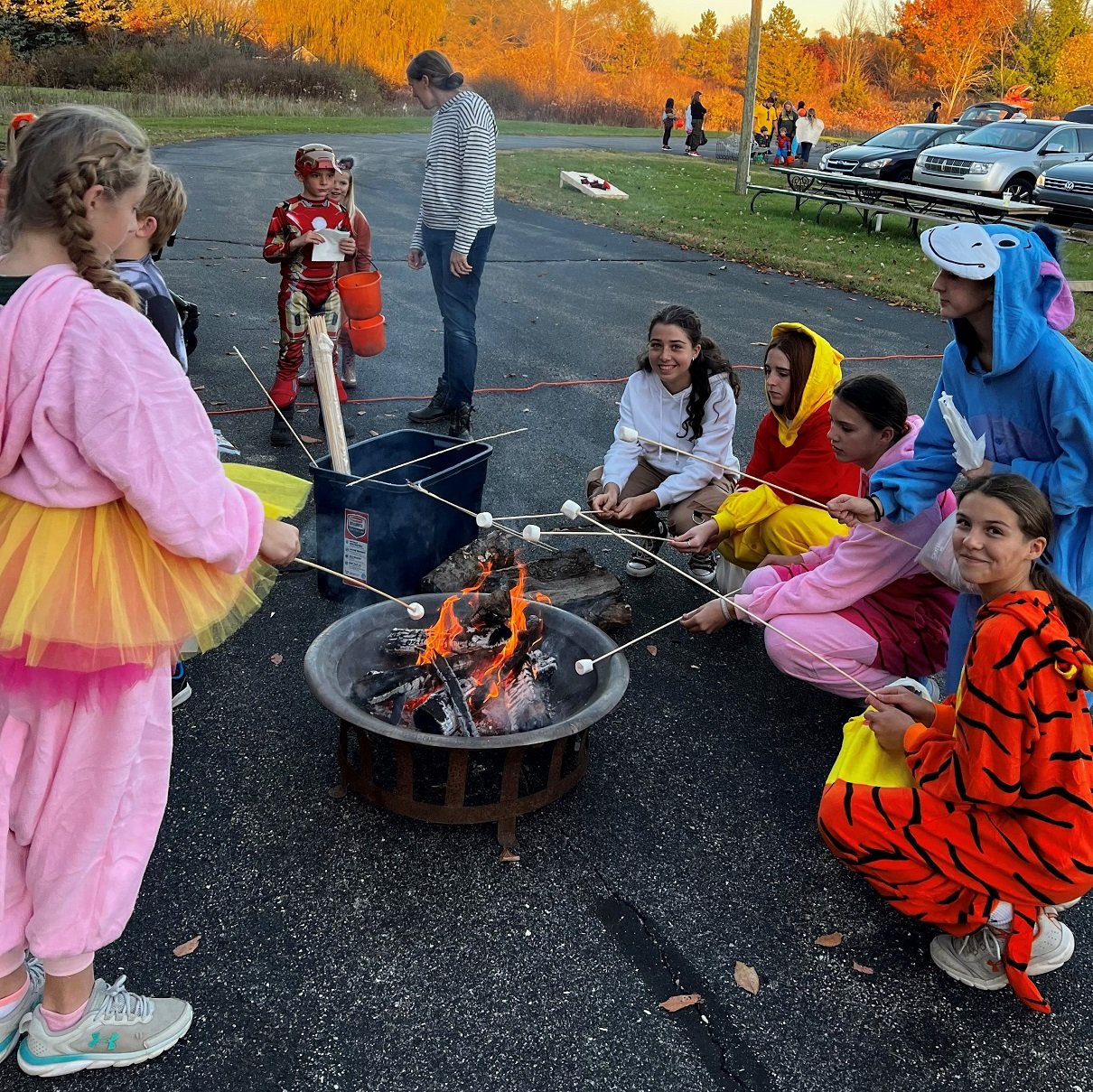 group of kids in costume roasting marshmallows