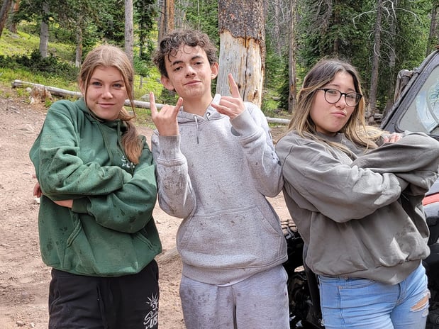 three teens making fun hand signals and faces