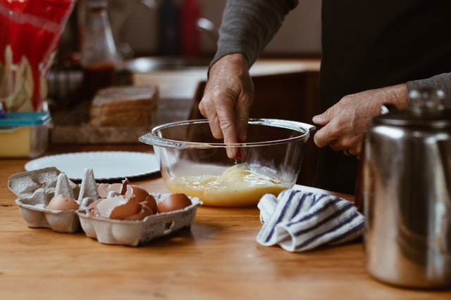 man beating eggs in the bowl