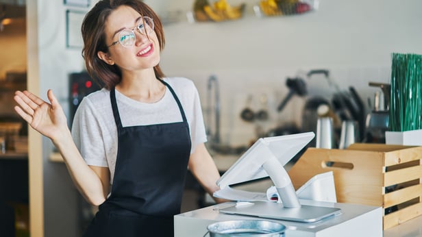 smiling cashier waving