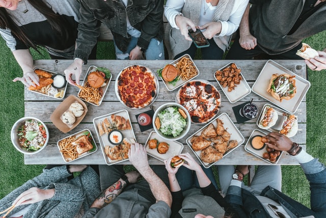 family picnic with a buffet of burgers, chicken and pizza