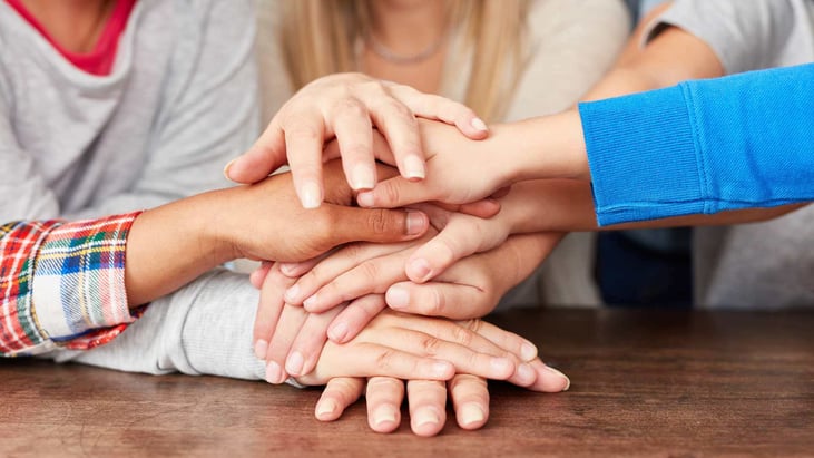 stack of hands on a table