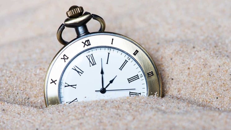 stop watch half buried in the sand