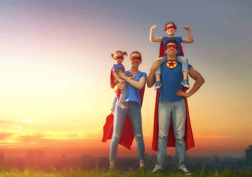 family with superhero shirts and capes