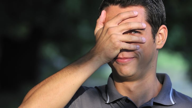 teen boy with hand over face