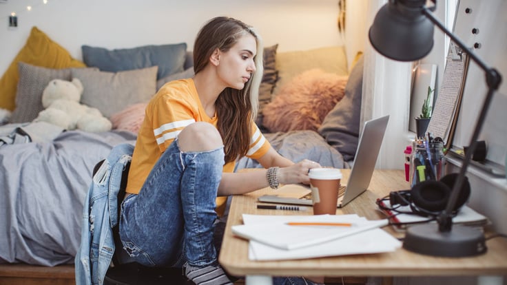 teen girl doing homework on computer