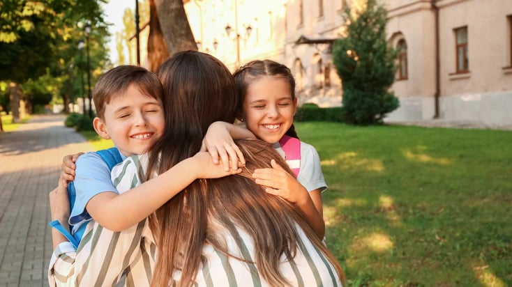 teen girl hugging two small children