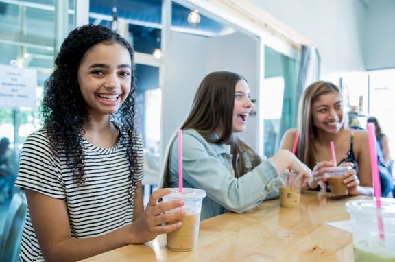 teen girls in coffee shop happy