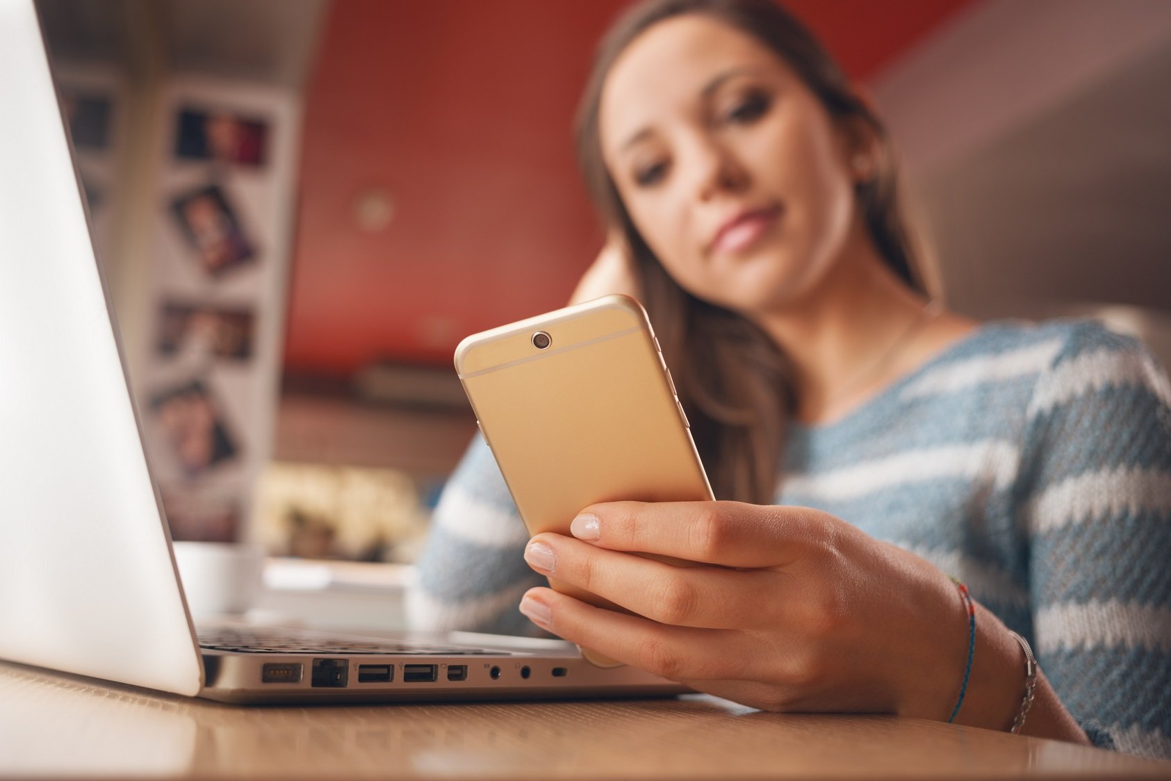 girl looking at phone and computer