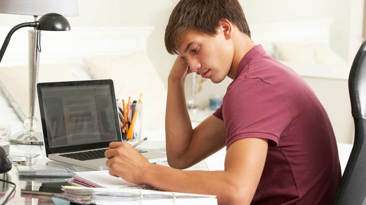 teenage boy studying in front of computer