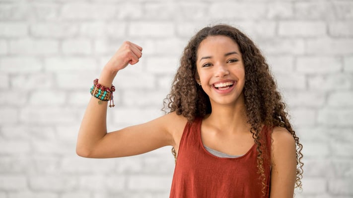 teenage girl flexing arm muscles
