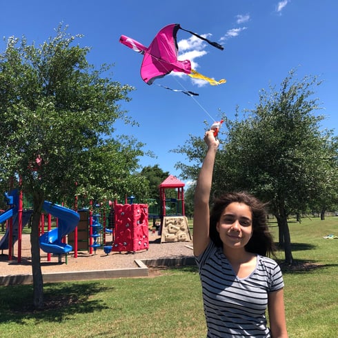 teenage girl flying pink bird kite