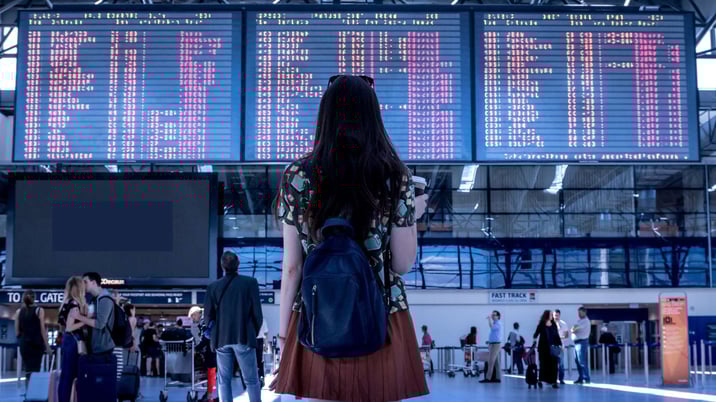 teenage girl looking at flight board at the airport