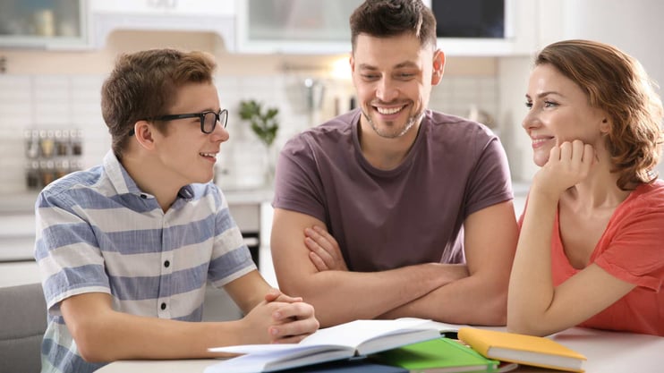 teenager doing homework with his parents