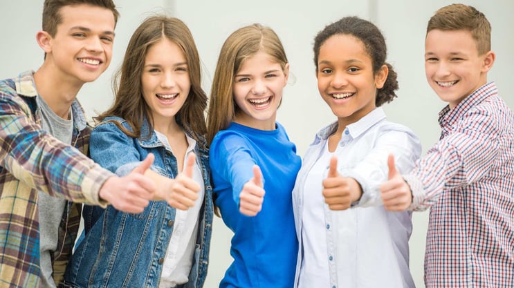 teenagers smiling with thumbs up