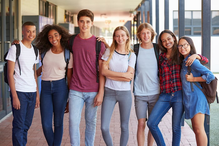 a group of teenagers standing together at school