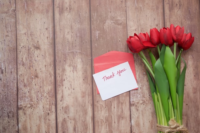 a bouquet of tulips and a thank you card