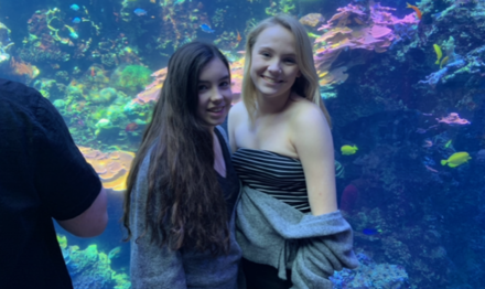 two girls at Atlanta aquarium with fish in background