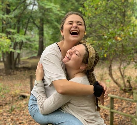 two girls hugging and laughing