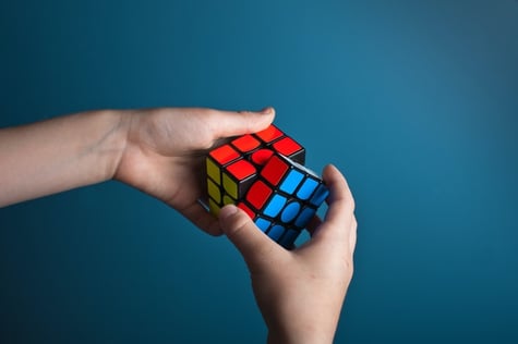 two hands working on rubics cube to illustrate understanding culture shock