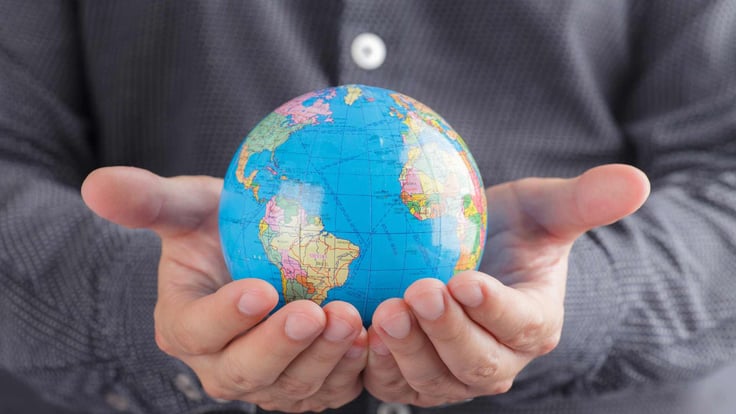 two male hands holding globe map ball
