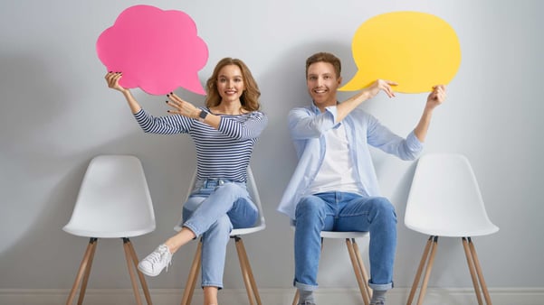 two people sitting and holding speech bubbles